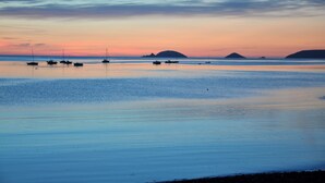 Une plage paisible, avec des bateaux, au coucher du soleil.