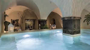 Un área de piscina con techos abovedados y pilares de piedra.