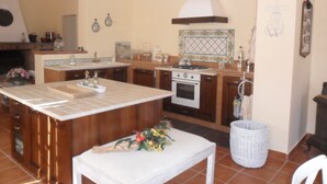 Una cocina con una isla central, estufa y lavaplatos.