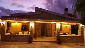 A house with a patio area, stone walls, and potted plants. - Villa with swimming pool facing the sea, for those who love peace and privacy (Marzamemi (Pachino) -SR)