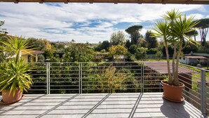 Un balcó amb vista a un jardí i cases.