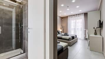 Une chambre d’hôtel moderne dotée d’une douche en verre, d’un lit avec vue et d’un petit espace bureau.
