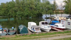 A marina with several boats docked, surrounded by dense greenery. - Family-friendly holiday home with heated swimming pool for 11 people + 2 baby's (Poroszló)