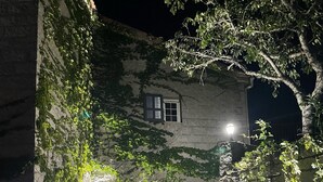 A stone building with ivy-covered walls, a staircase leading to a second-floor window, and a lit lamp post. - Mansion - SORBOLLANO (Sorbollano)