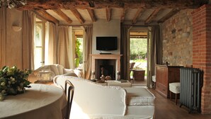 A cozy living room with a fireplace, comfortable seating, and a television. - LA CRIOLDA CHARMING VILLA, Lake View, Served Breakfast, Butler, Pool, Gym, Sauna (San Felice del Benaco)
