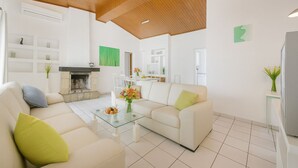 Una sala moderna con chimenea, dos sofás, una mesa de centro y un comedor.