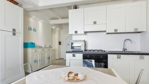 A modern kitchen with white cabinetry, a built-in oven, a microwave, and a gas stove. - To complete (Porto Rotondo)