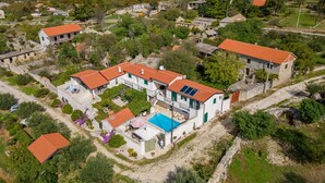 An aerial view of a residential area with stone buildings, a swimming pool, and a red-tiled roof. - Villa Torine ZadarVillas (Zapužane)