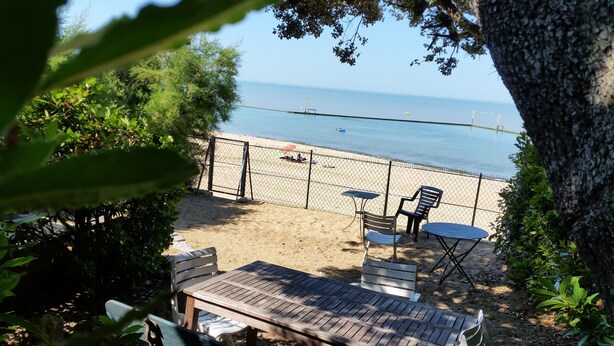 A beach view with a fenced area, wooden benches, and a table. - Fouras, Villa with character, direct private access to the beach. (Fouras)