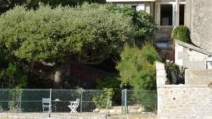 A two-story house with a tiled roof, surrounded by greenery and a fenced area. - Fouras, Villa with character, direct private access to the beach. (Fouras)