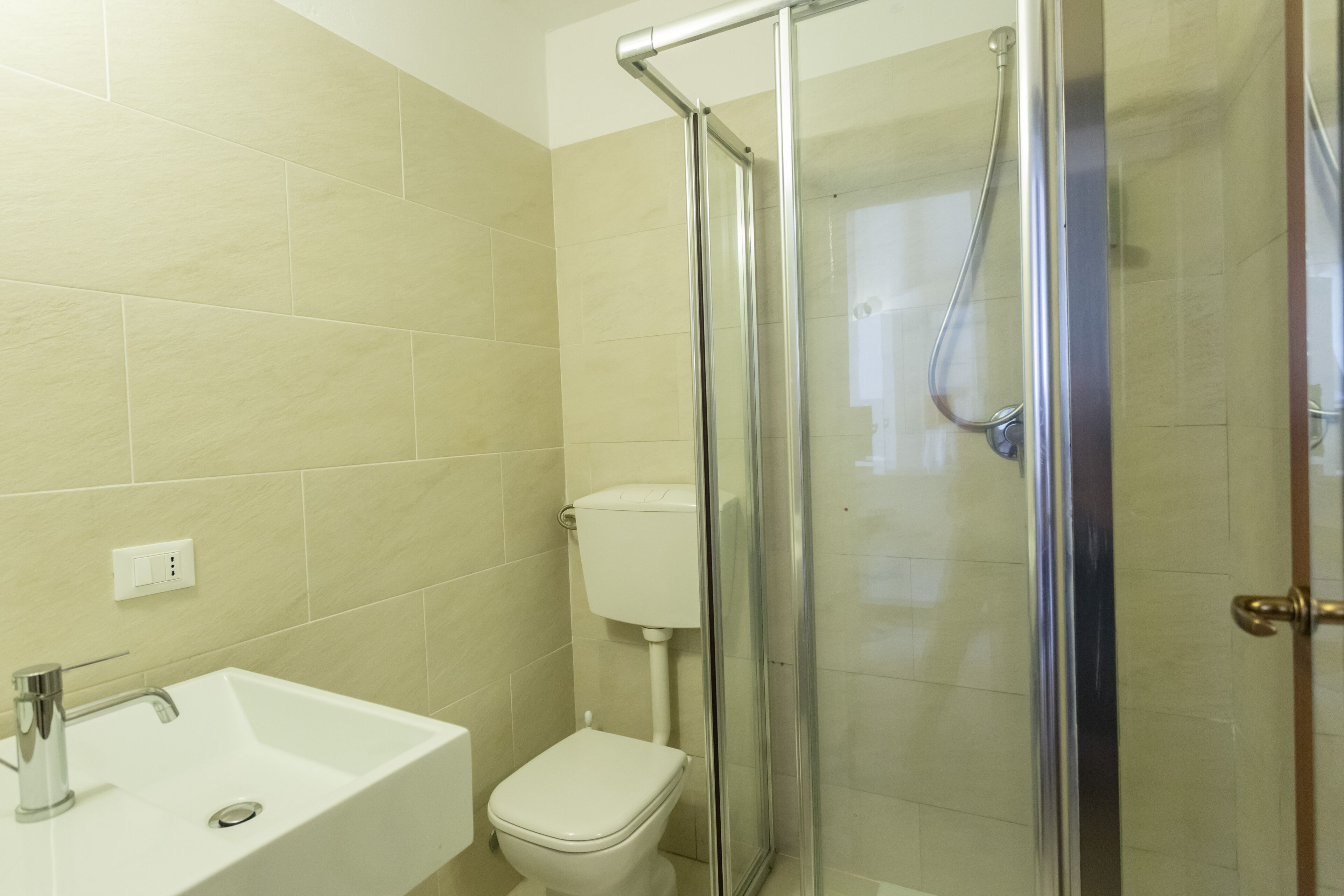 Ein Badezimmer mit Waschbecken, Toilette und Duschkabine aus Glas.