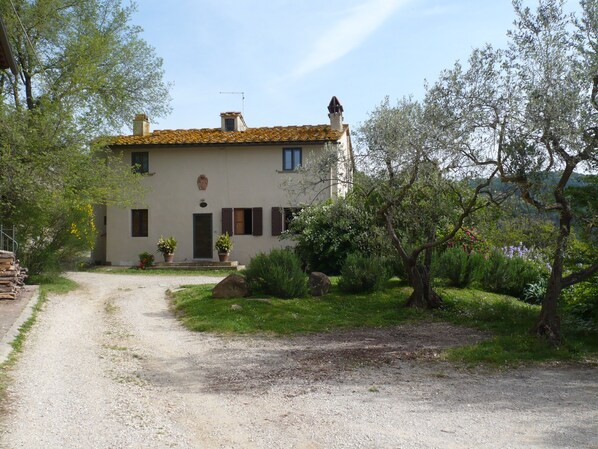 Traditional Mediterranean villa with a central entrance and lush garden surroundings.