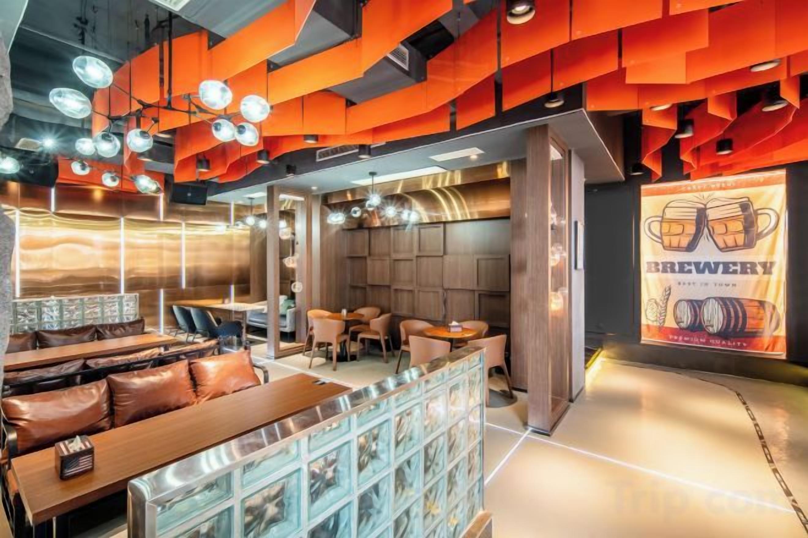 A modern restaurant interior with seating arrangements, a bar area, and a prominent beer advertisement.