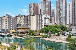A residential area with high-rise buildings, a traditional pavilion, and a swimming pool.