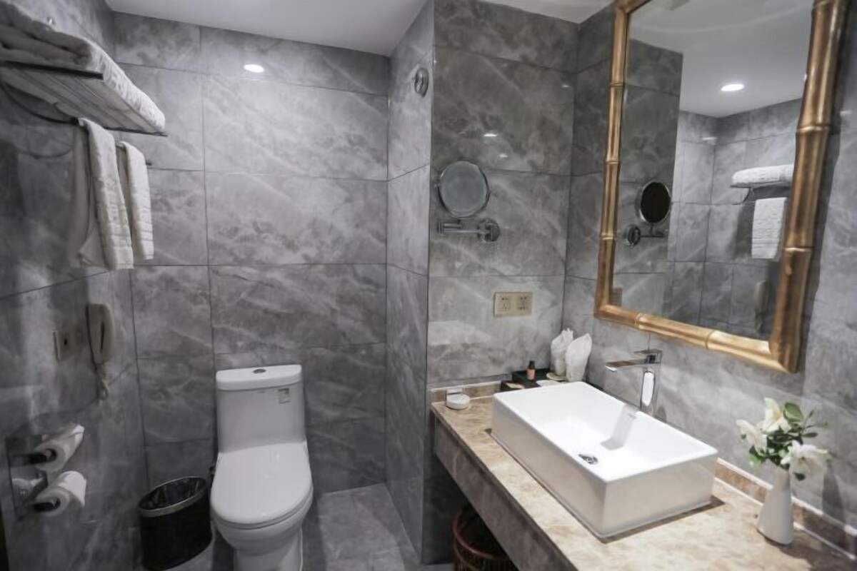 A modern bathroom with a toilet, sink, and mirror.