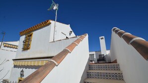 Un bâtiment blanc avec un escalier carrelé et une rampe en bois.