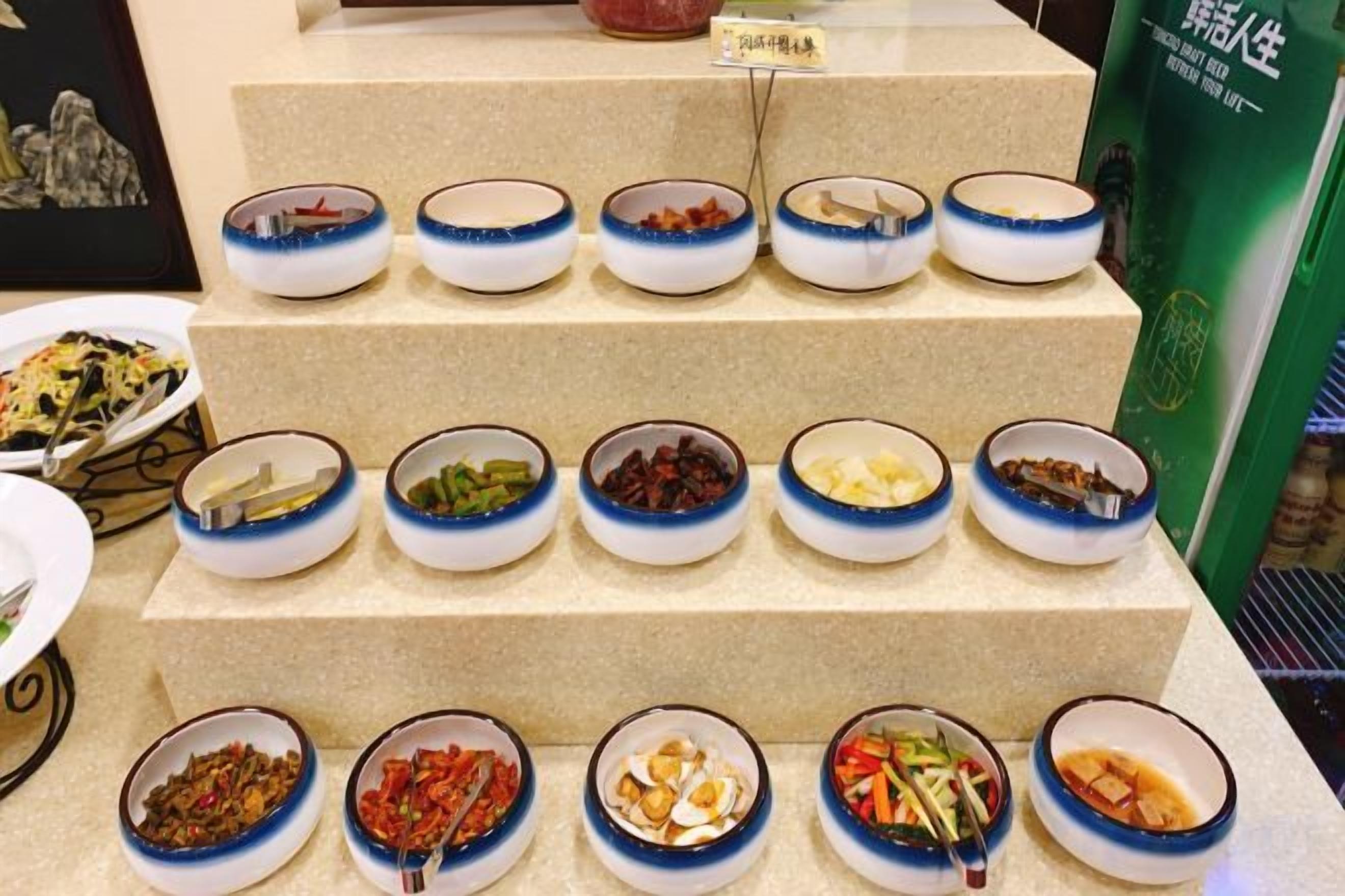A tiered display of various food dishes in bowls.