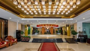 A spacious lobby with a red carpet, a chandelier, and a circular red lantern decoration. - Hongqi Hotel (Datong)