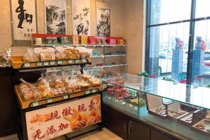 A bakery display with various baked goods and a sign in a foreign language.