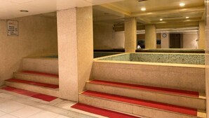 A pool area with steps leading into it, tiled walls, and a ceiling with recessed lighting. - Hongqi Hotel (Datong)