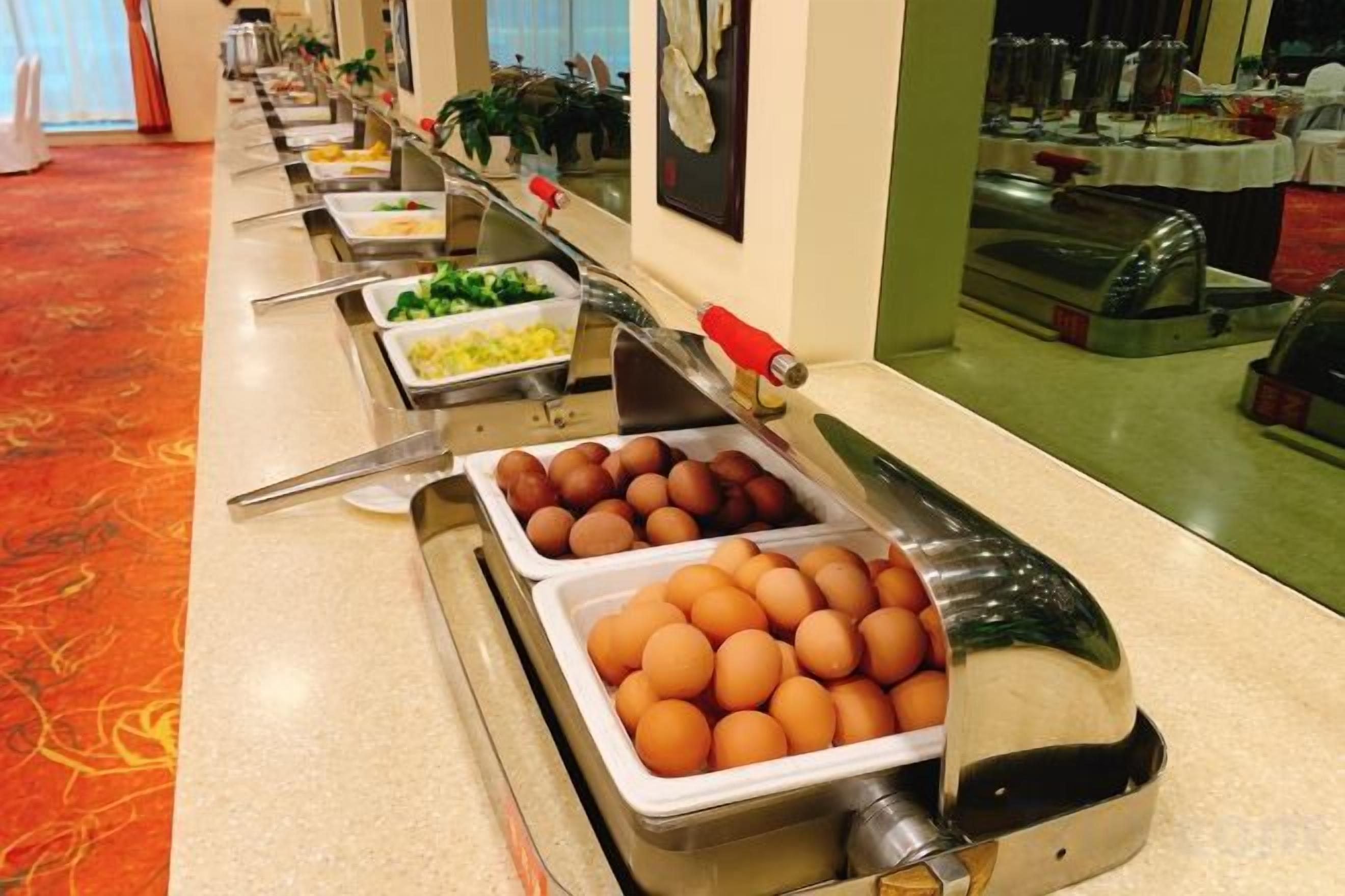 Un buffet proposant une variété de plats, notamment des œufs et des légumes.