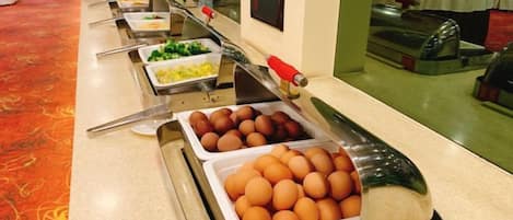 Un buffet proposant une variété de plats, notamment des œufs et des légumes.