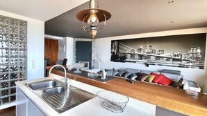 A modern kitchen with a built-in wine rack, a large window, and a cityscape mural on the wall. - Beachfront Apartment - By the SEA (Vila do Conde)