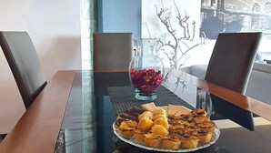 A dining table with a plate of pastries and a glass bowl of red berries. - Beachfront Apartment - By the SEA (Vila do Conde)