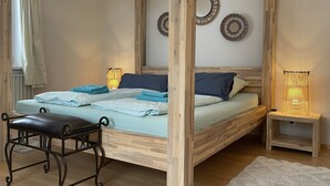 A neatly arranged bedroom with a wooden bed, bedside tables, a bench, and decorative wall art. - Sunny, spacious & fully equipped, castle views, close to lake/beach, restaurants (Schwangau)