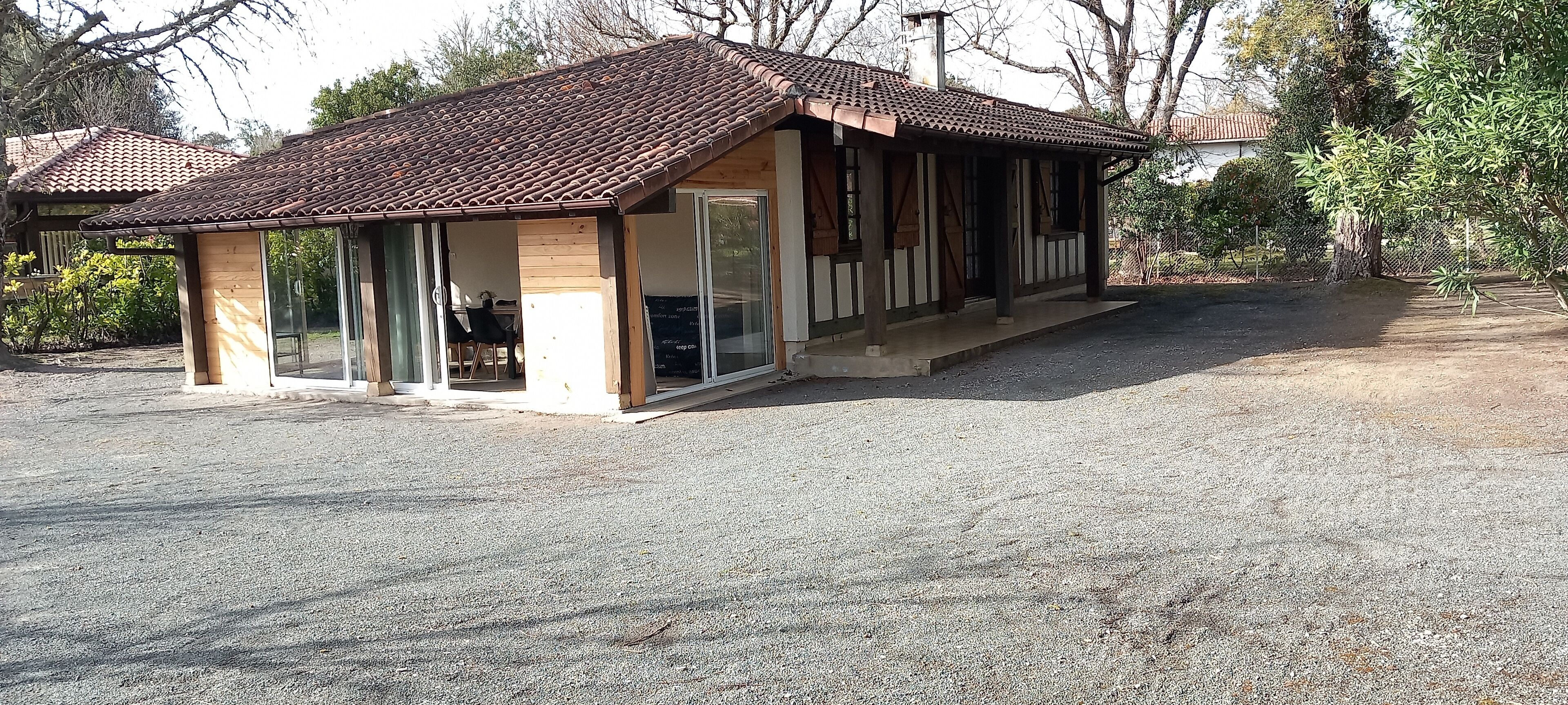 A small, single-story building with a tiled roof and large glass windows.