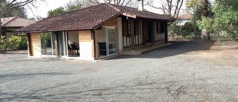 A small, single-story building with a tiled roof and large glass windows.