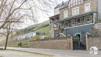 Ein zweistöckiges Gebäude mit einer Stein-Fassade, einem Balkon und einer Treppe, die zum Obergeschoss führt.