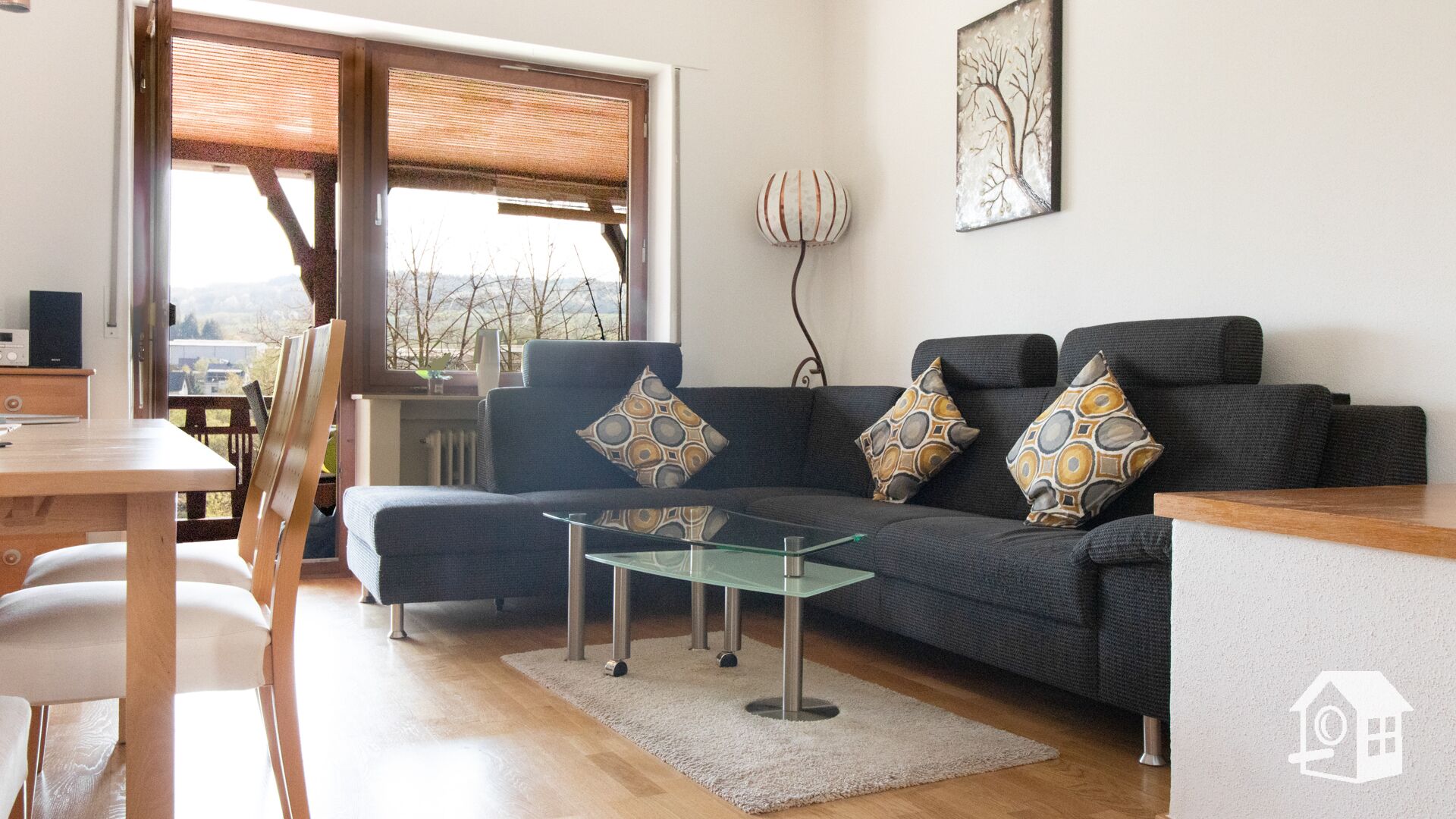 Ein modernes Wohnzimmer mit einer Couch, einem Couchtisch und einem Essbereich mit Stühlen.