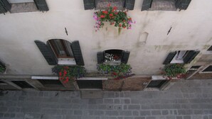 A building facade with multiple windows, some with shutters, and flower boxes with red and purple flowers. - Formosa Apartment: A Wonderful Holiday in the Heart of Gorgeous Venice (Venezia)