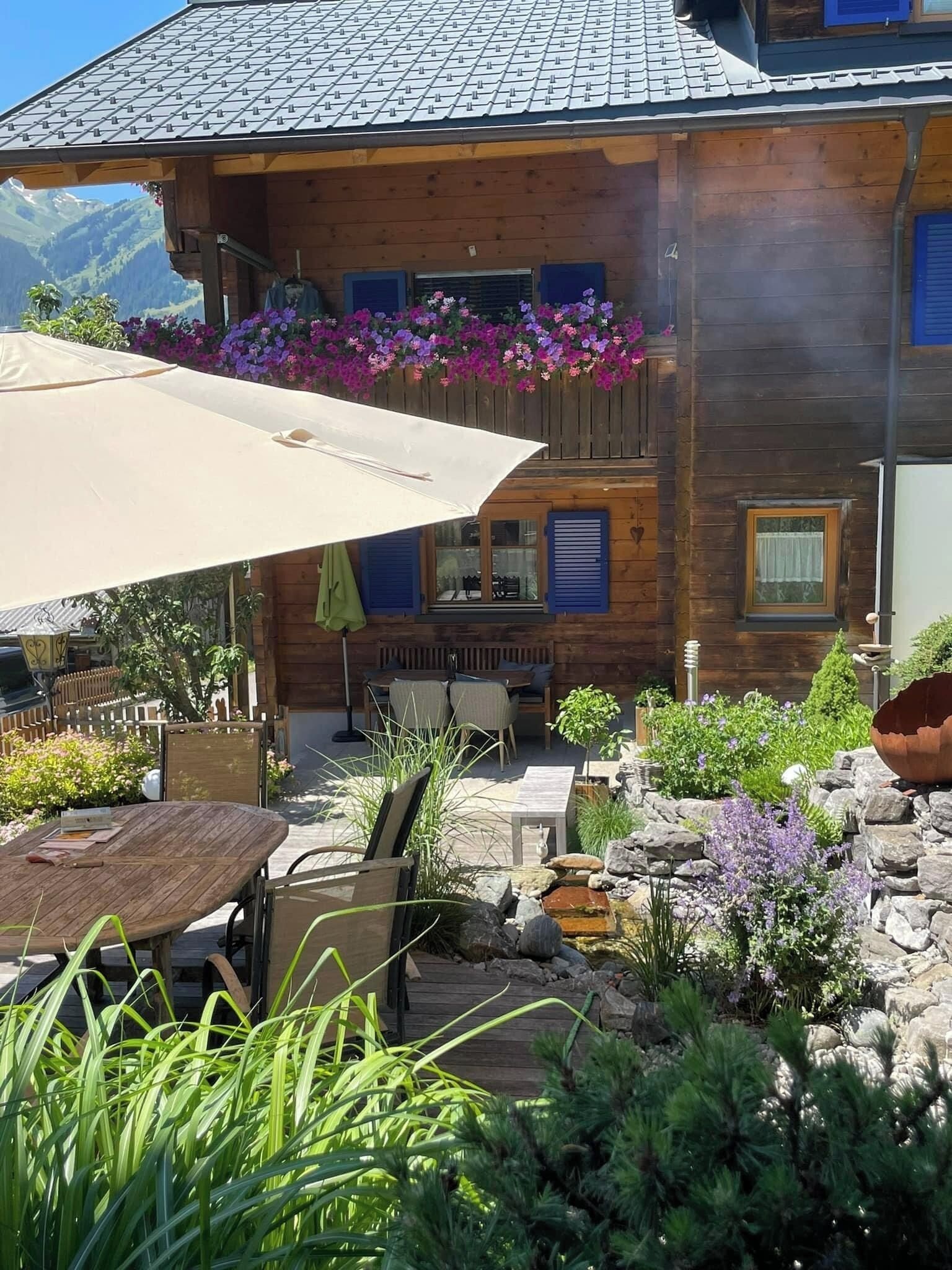 Un chalet en bois doté d’un balcon, d’un espace extérieur aménagé pour s’asseoir et d’un jardin.