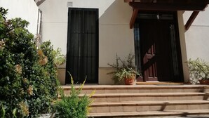 Un edificio con fachada blanca, un balcón con barandilla de madera y un letrero que dice "VILLA SEFINA".