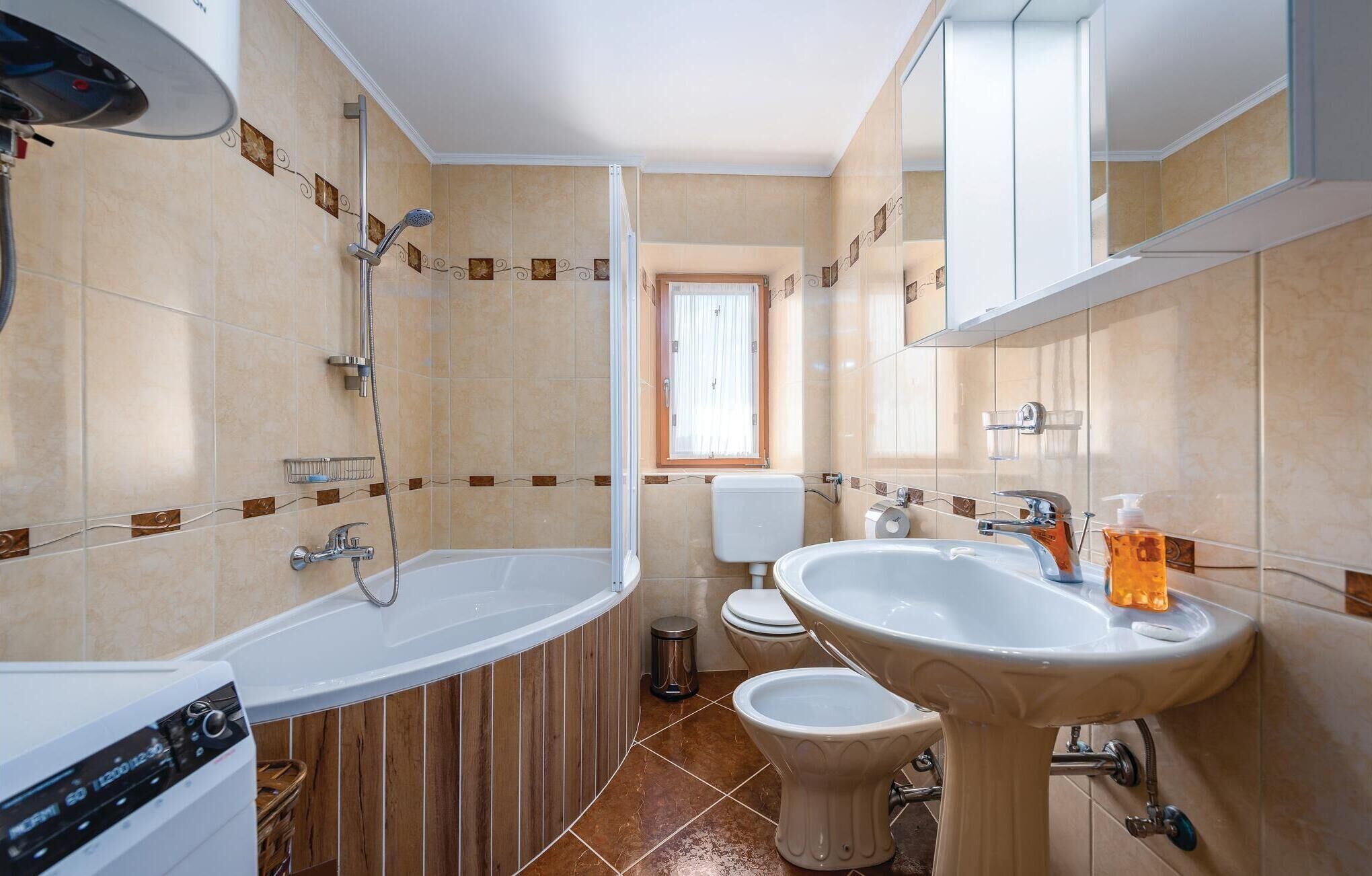 Een badkamer met een bad, een wastafel, een toilet en een douche.
