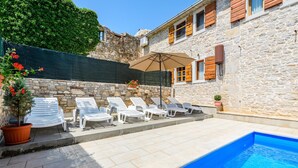 A stone building with a swimming pool, white lounge chairs, and a potted plant. - Lovely home in Medancici (Medancici)