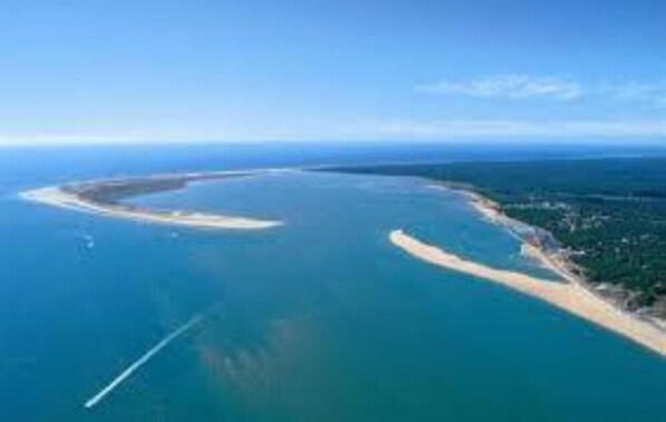 Overlooking a serene coastal bay with a sandy beach and lush greenery.