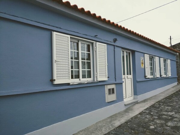 A two-story building with a blue exterior and white window shutters.