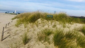 A beach with sand dunes and a clear sky. - Quiet upper apartment in the middle of Norddeich for 4 people + baby (Norden)