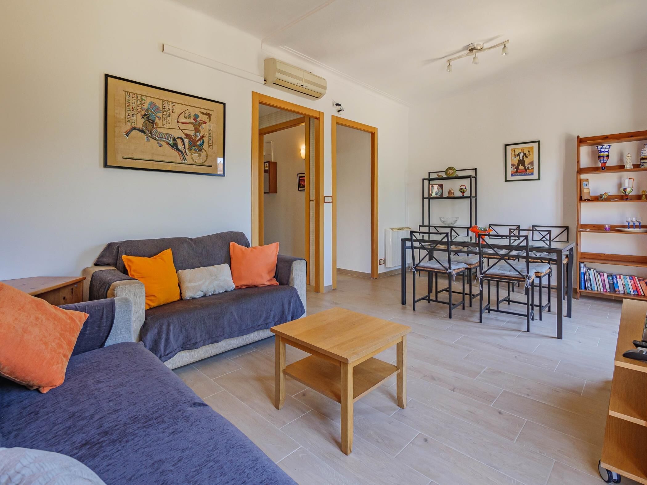 Ein modernes Wohnzimmer mit Sofa, Couchtisch und Essbereich mit Stühlen und Tisch.