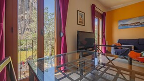 Una sala de estar moderna con una mesa de vidrio, un televisor y un sofá.