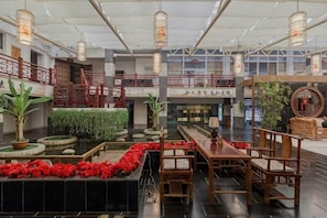 A spacious lobby with a central water feature, seating areas, and a staircase leading to an upper level. - Qingcheng Country Villa (Dujiangyan)