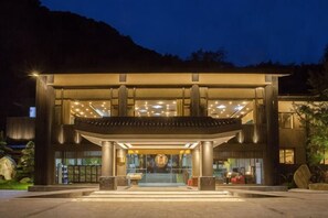 A modern hotel entrance with a large glass facade, a central entrance, and a well-lit exterior. - Qingcheng Country Villa (Dujiangyan)