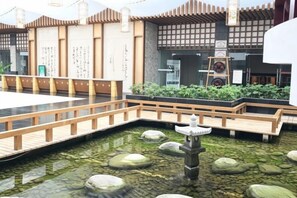 A traditional Japanese-style courtyard with a wooden bridge, a koi pond, and a stone lantern. - Qingcheng Country Villa (Dujiangyan)