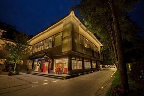 A two-story building with a traditional architectural style, featuring a prominent entrance and a well-lit facade. - Qingcheng Country Villa (Dujiangyan)