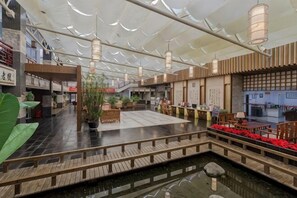 Amplio espacio interior con una fuente central, suelo de madera y decoración tradicional.