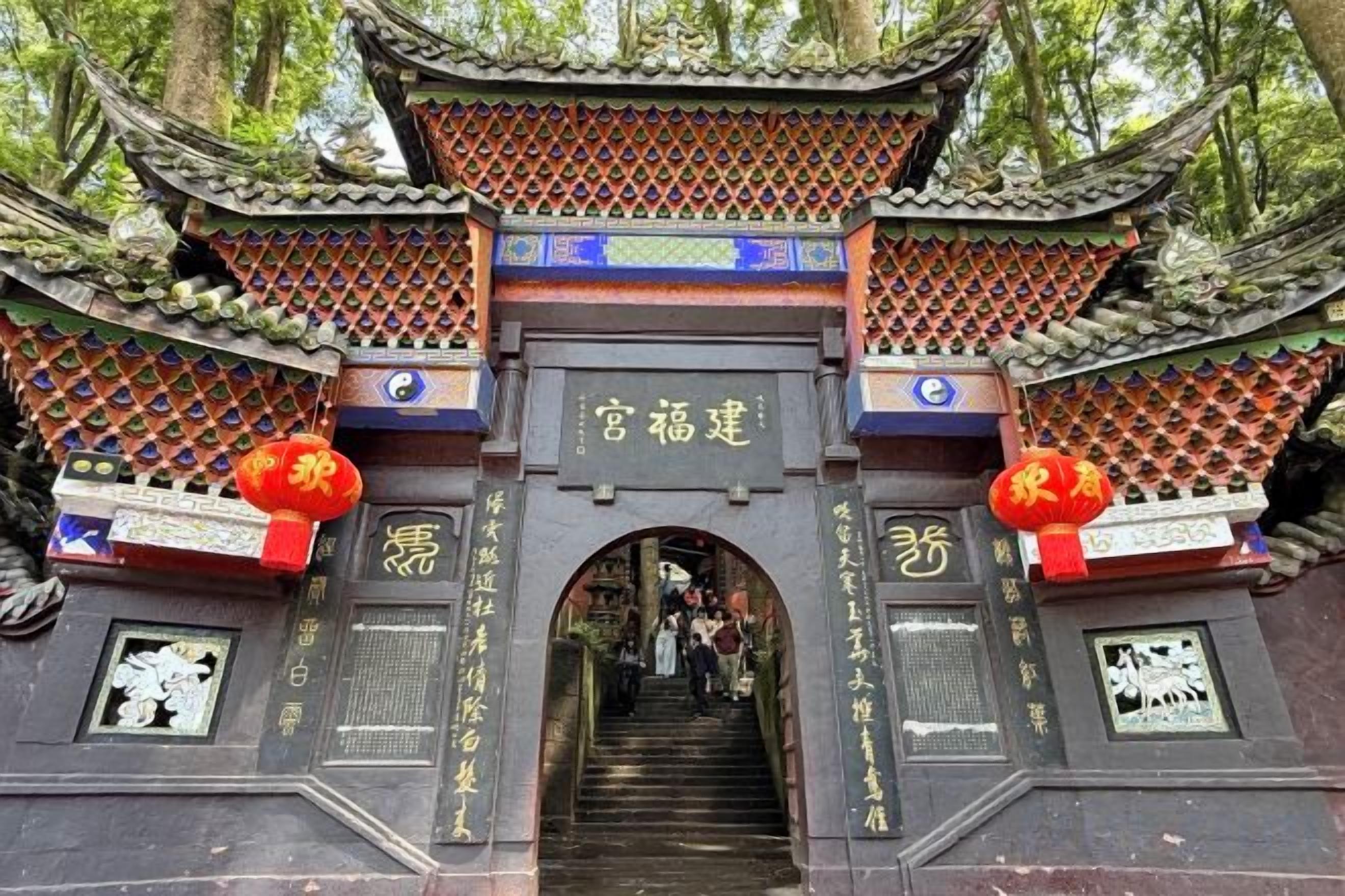 A traditional Chinese gate with intricate roof designs and a staircase leading up to it.