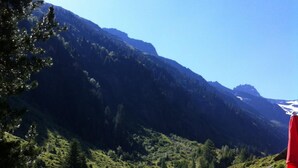 A mountainous landscape with a small cabin featuring a corrugated metal roof and a wooden fence. - New, stylish top floor apartement, free Wifi, bus stop directly at the house (Ramsau im Zillertal)